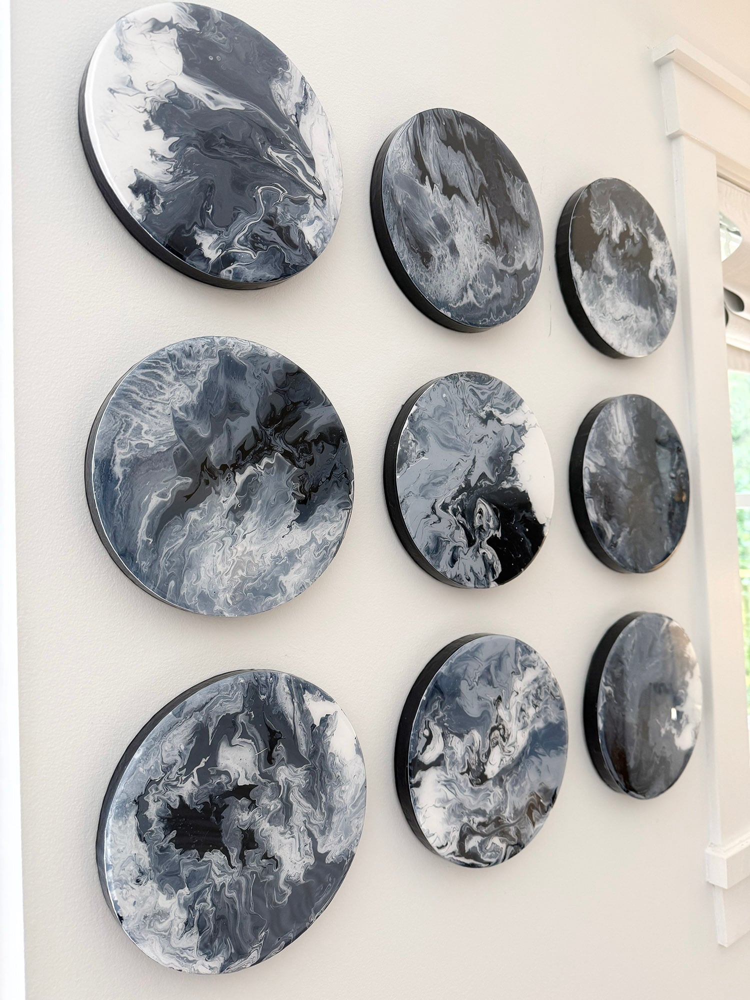 Original coastal artwork by Tracy Svendsen — nine acrylic circle paintings on wood with epoxy finish for a primary bedroom