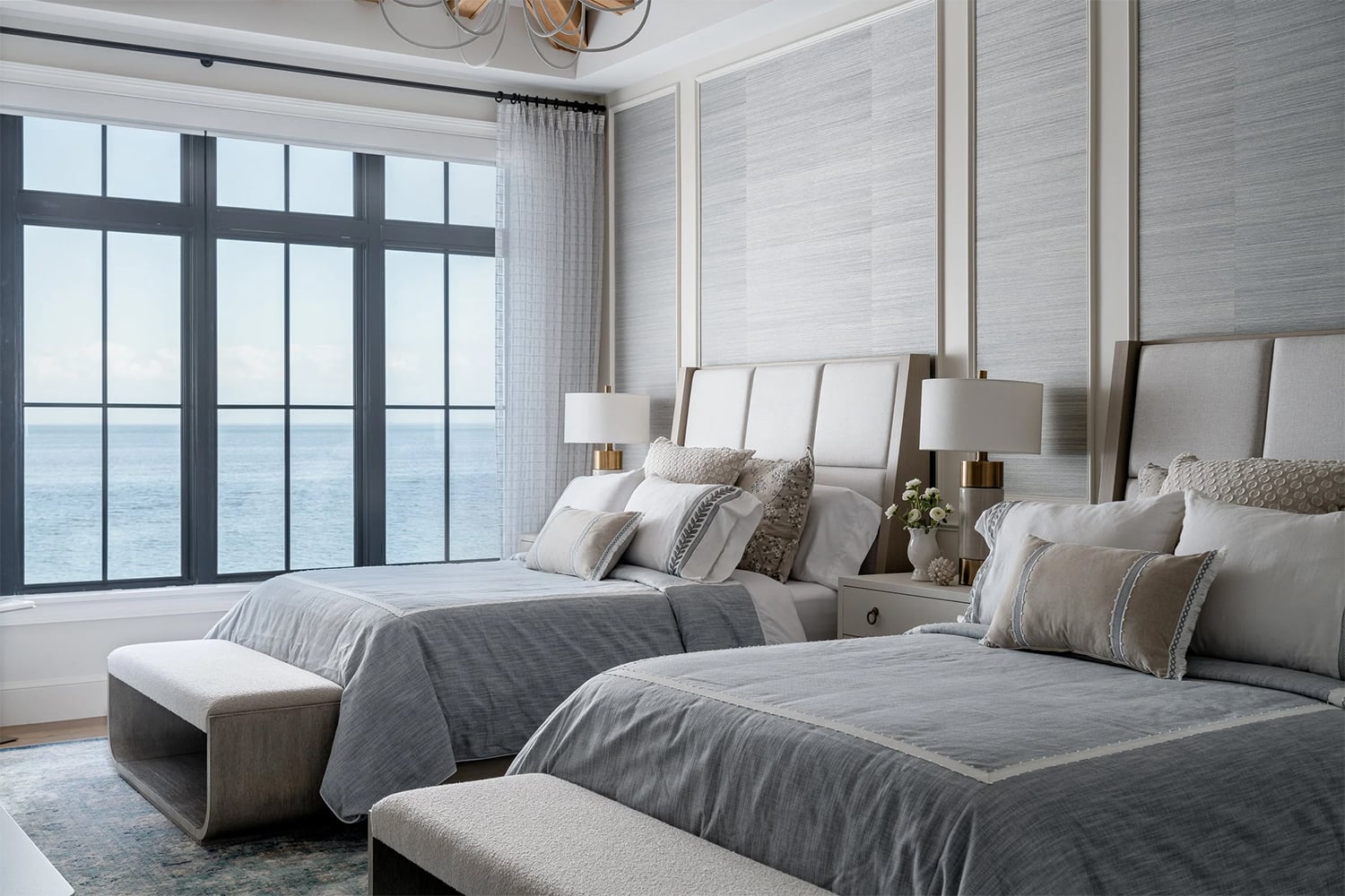 Coastal bedroom design with ocean views and a blue, gray, brown and white color palette.