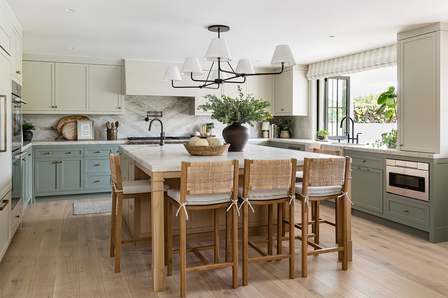 Coastal kitchen with two-tone cabinets, cream upper and green lower, with light oak flooring.