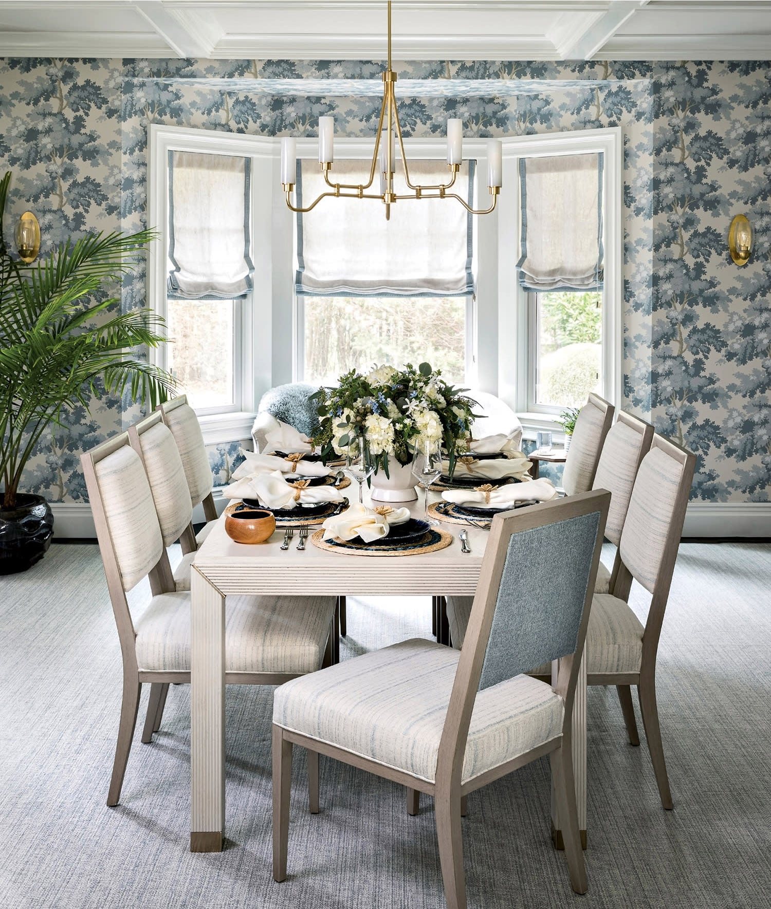 Modern coastal dining room with striped area rug and dining chairs with botanical wallpaper