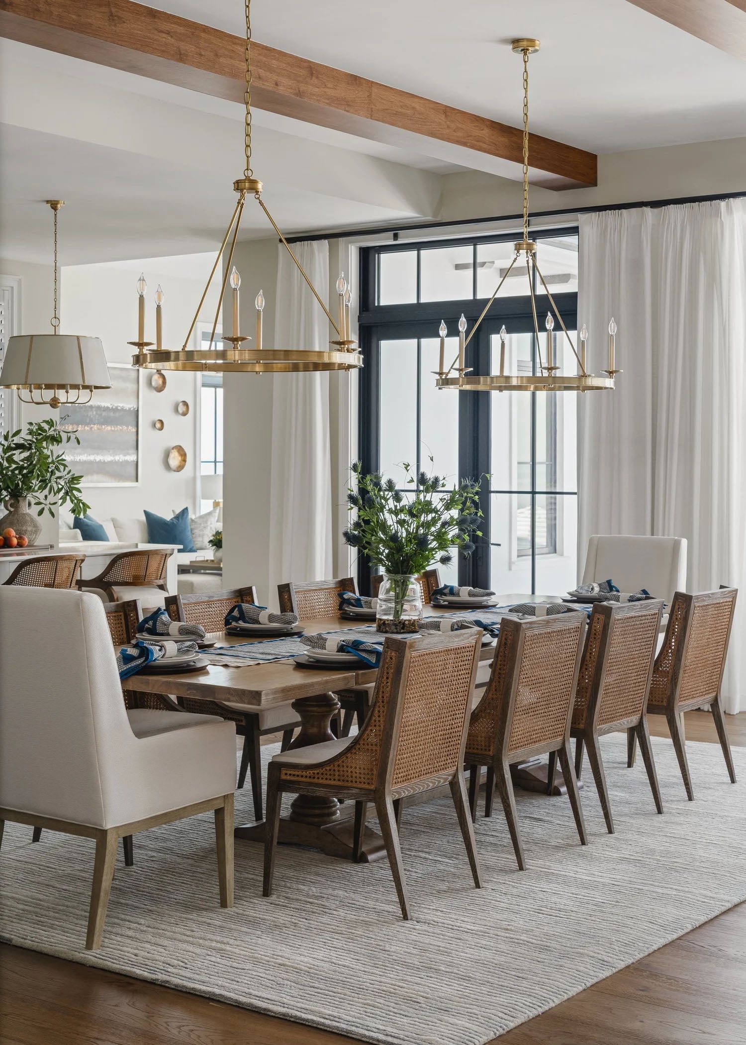 Modern coastal open-concept dining room with warm wood flooring and white walls.