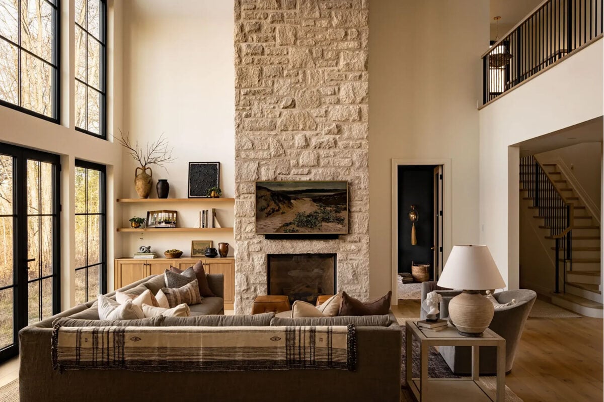 Modern rustic living room with a stone fireplace, light oak flooring and a brown sectional
