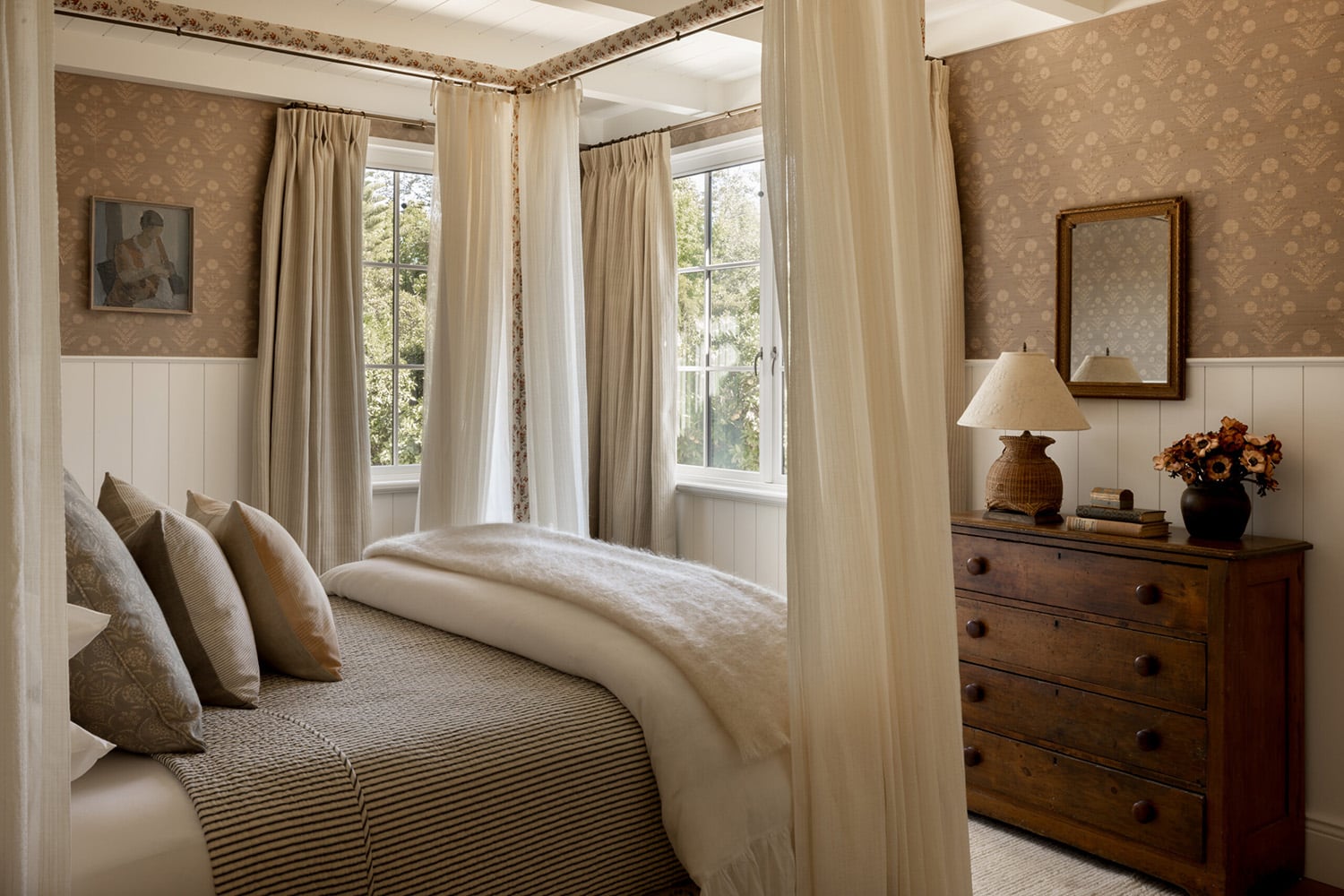Farmhouse bedroom with canopy bed, floral wallpaper and wainscotting