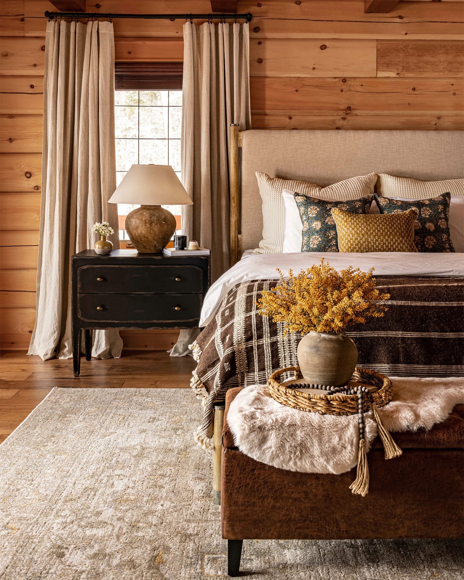 Rustic farmhouse bedroom with wood walls, and warm earth tones