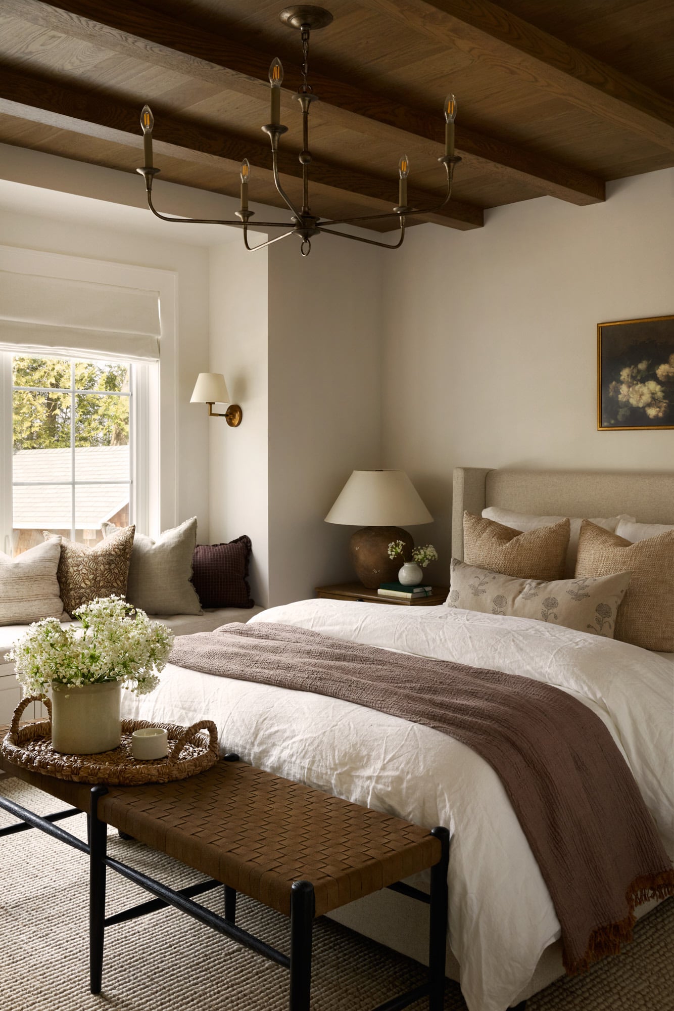 Modern farmhouse bedroom with dark wood ceiling and flooring, with a white linen duvet cover.