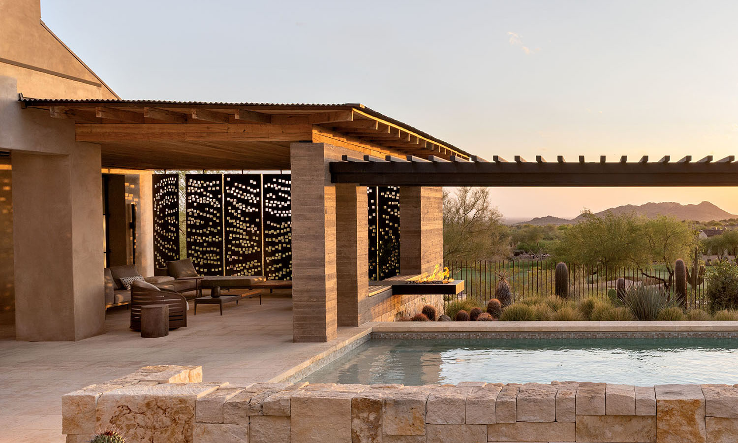 Exterior of a rustic Southwestern desert home with perforated steel panels for privacy