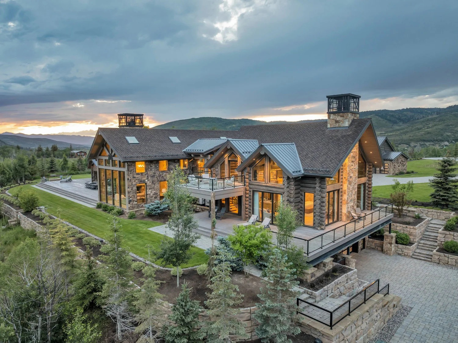 The exterior of a handcrafted log home with a pitched profile and extensive glazing
