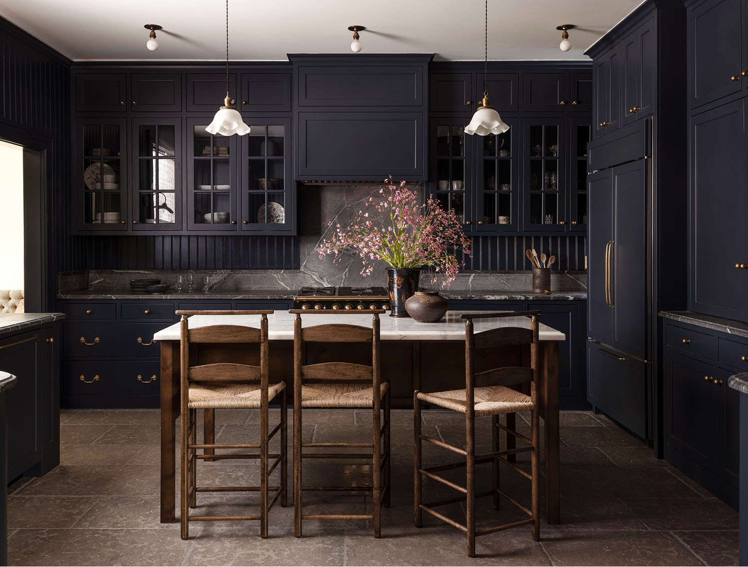 Kitchen with dark blue cabinets and backsplash, wood finishes, and tile flooring.