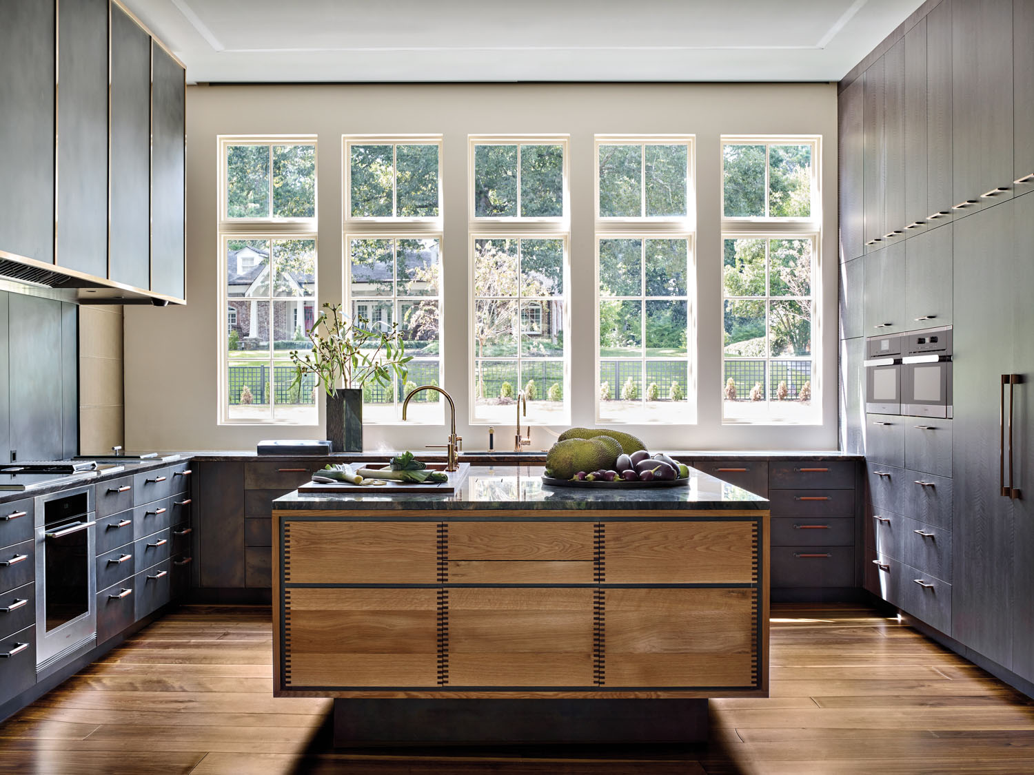 Contemporary kitchen with blue cabinets, patinated metal, oak island and blue quartzite countertops.