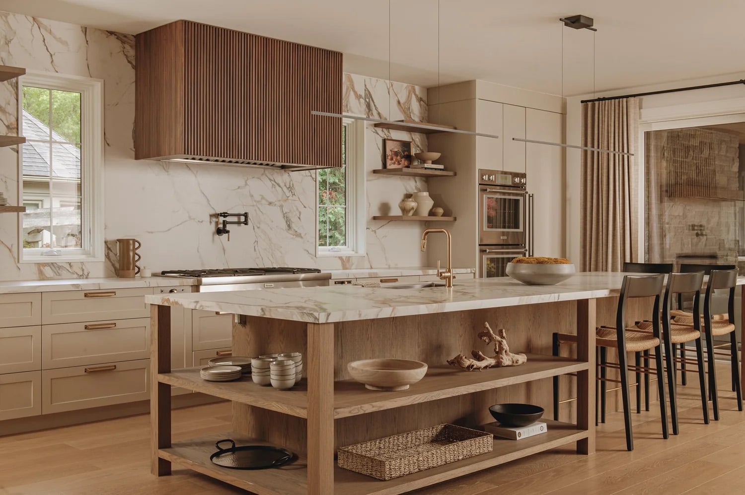 A kitchen with open shelving on the walls and at the base of the island