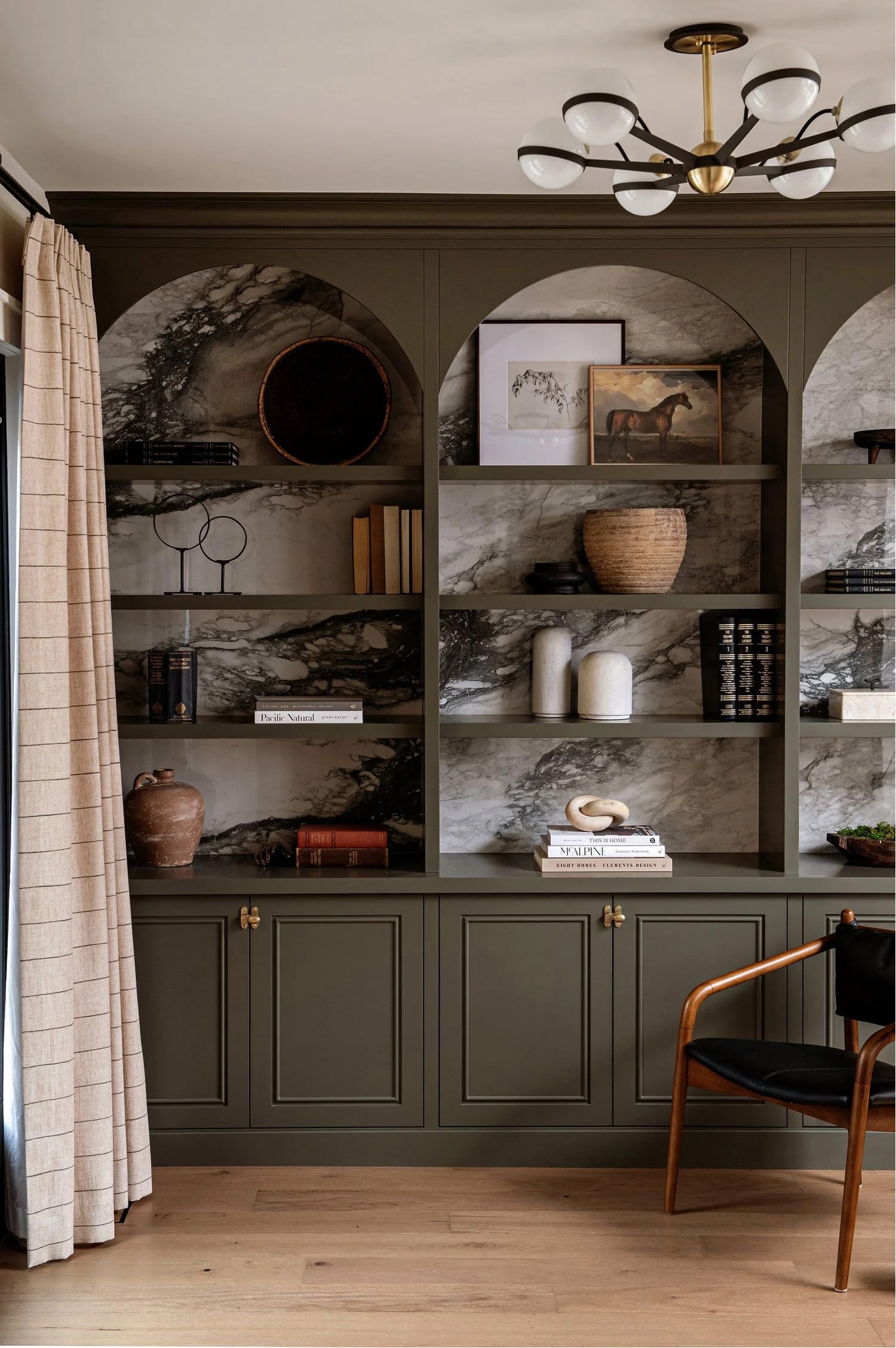 Open shelf styling in built-in olive green cabinetry
