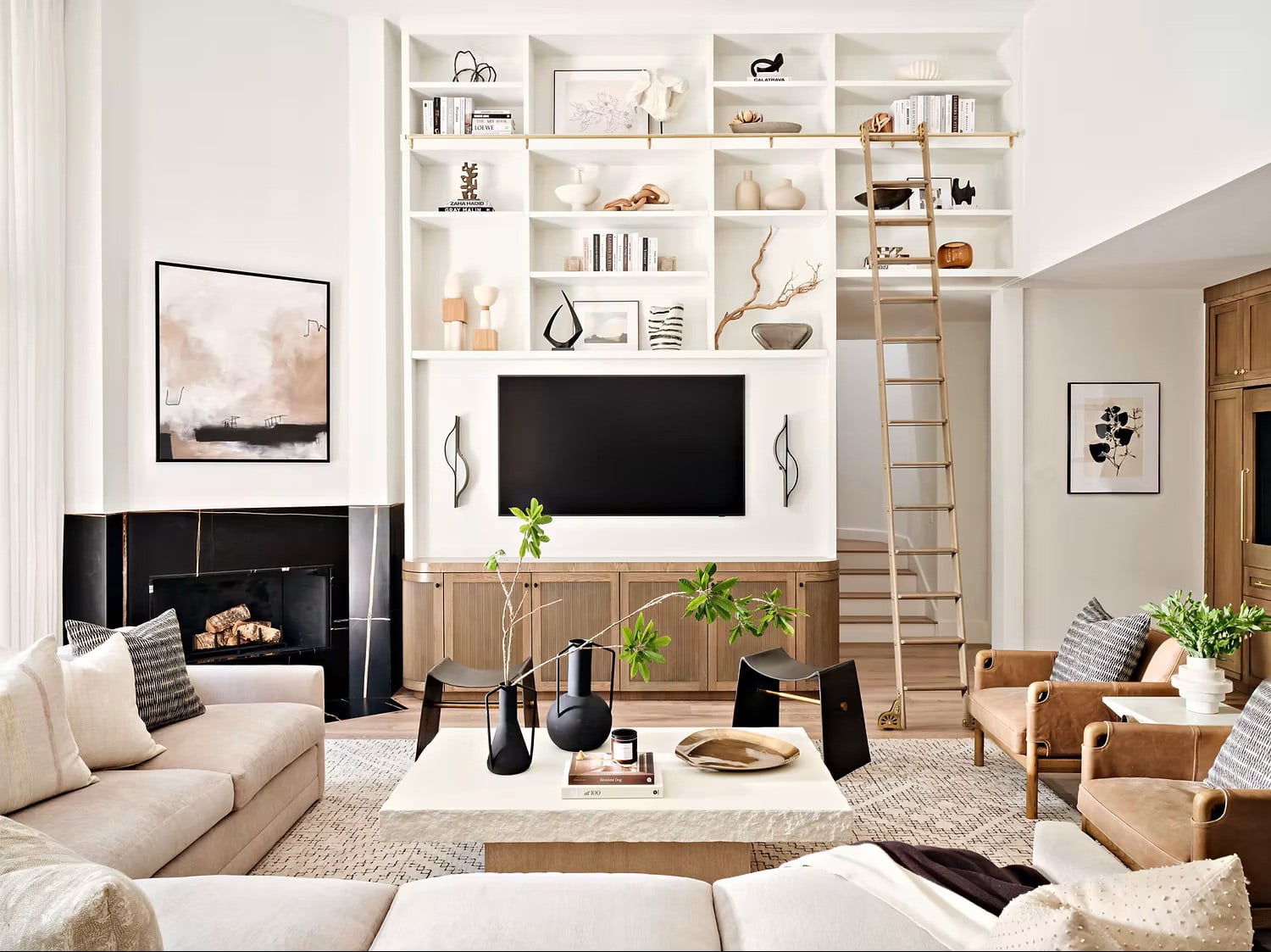 Open shelving above the tv in a modern organic living room with a black, white and wood toned color scheme