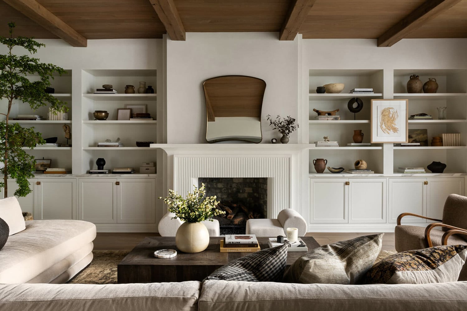 A living room with four sections of open shelving on either side of a fluted fireplace