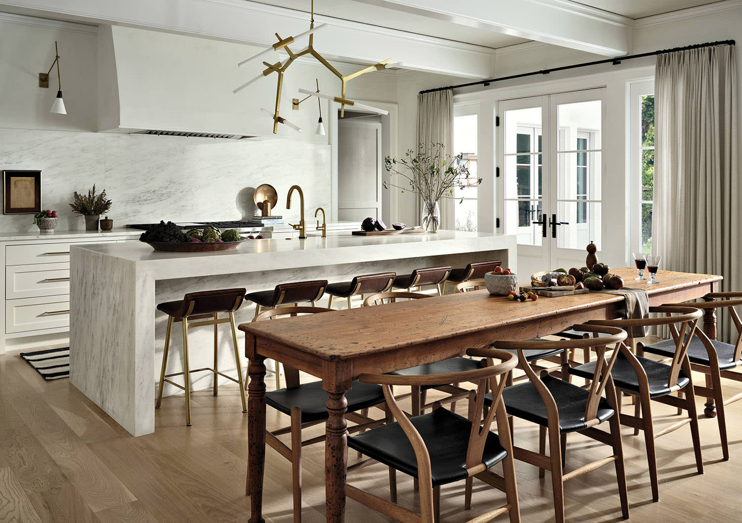 Modern kitchen with white cabinets, rustic wood dining table and old-world charm. 