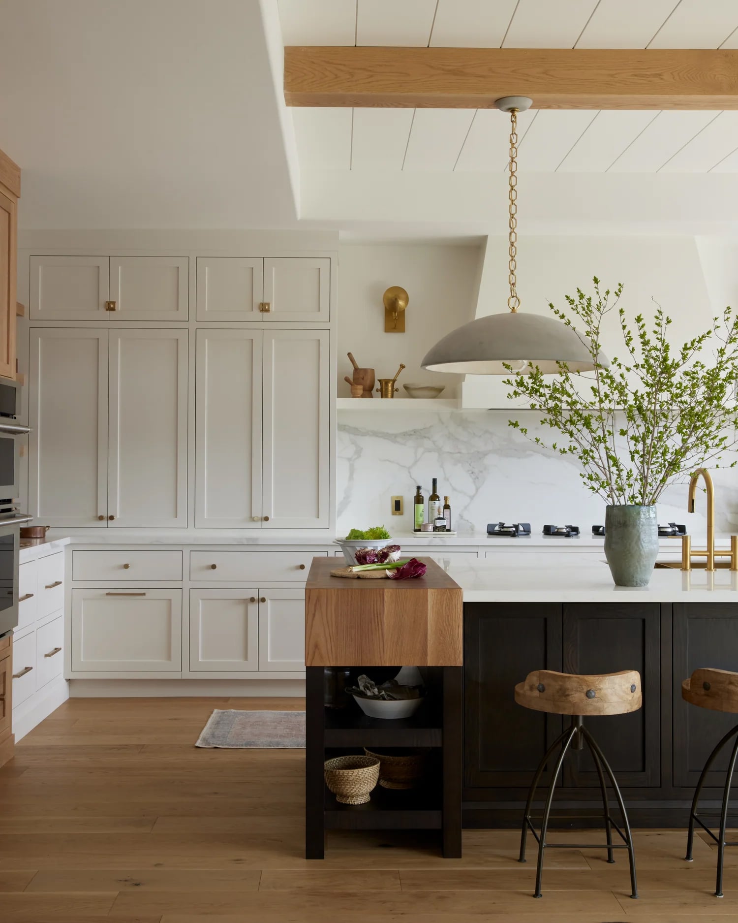 Modern kitchen with black island and white cabinets, Benjamin Moore Seapearl.
