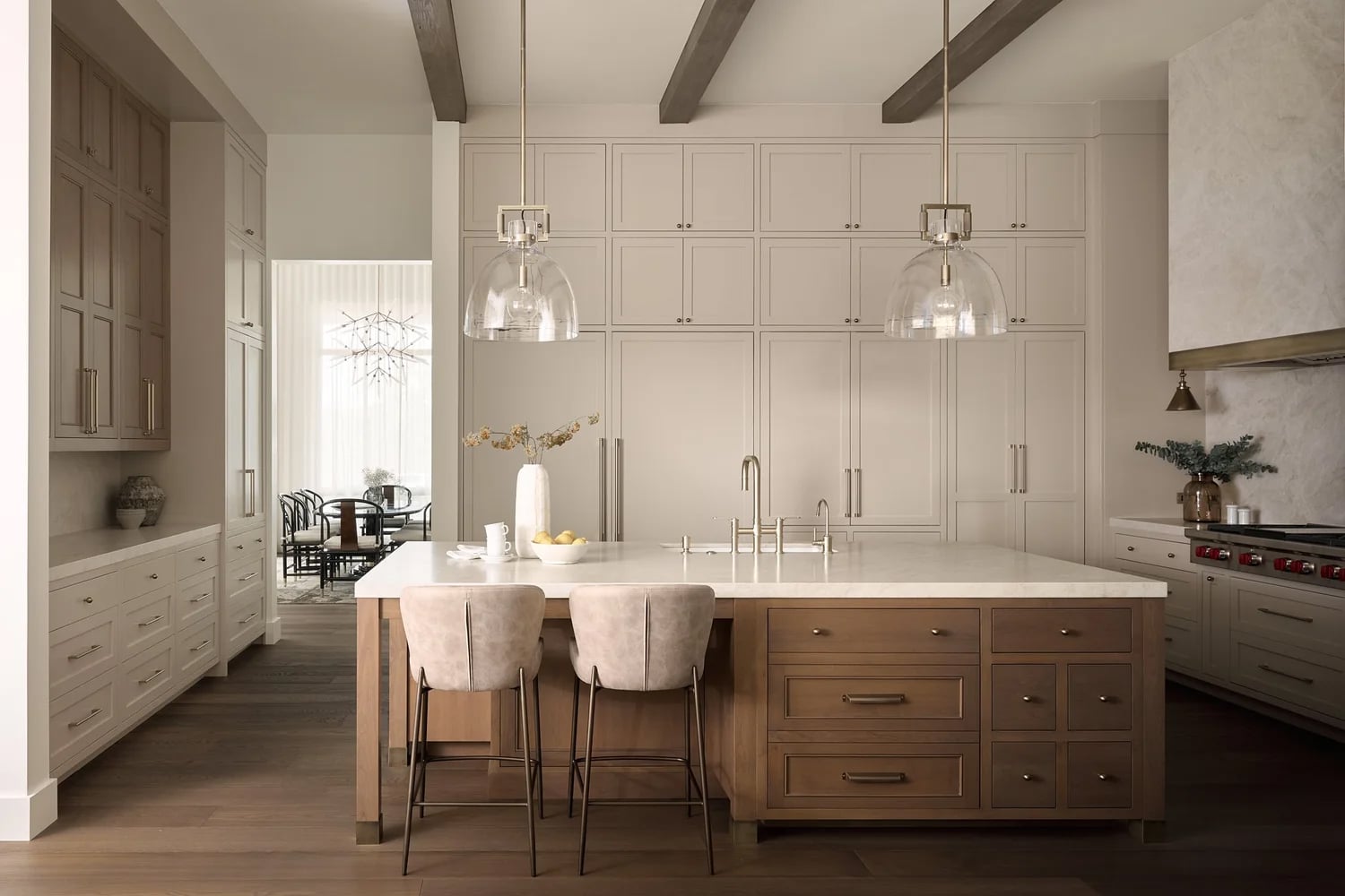 Kitchen With warm white cabinets, wood island and modern pendant lighting.
