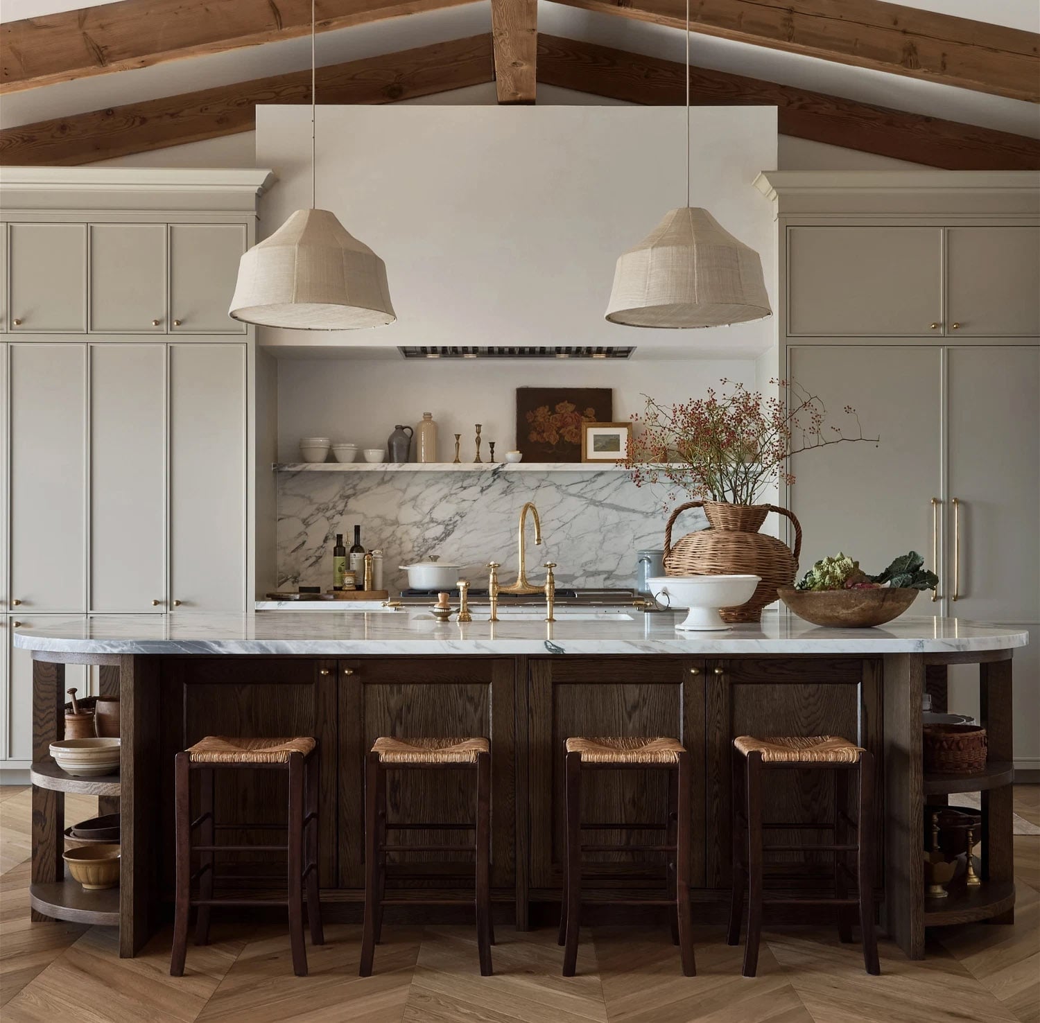 Modern organic kitchen with open shelving, dark wood island and veined marble countertops.