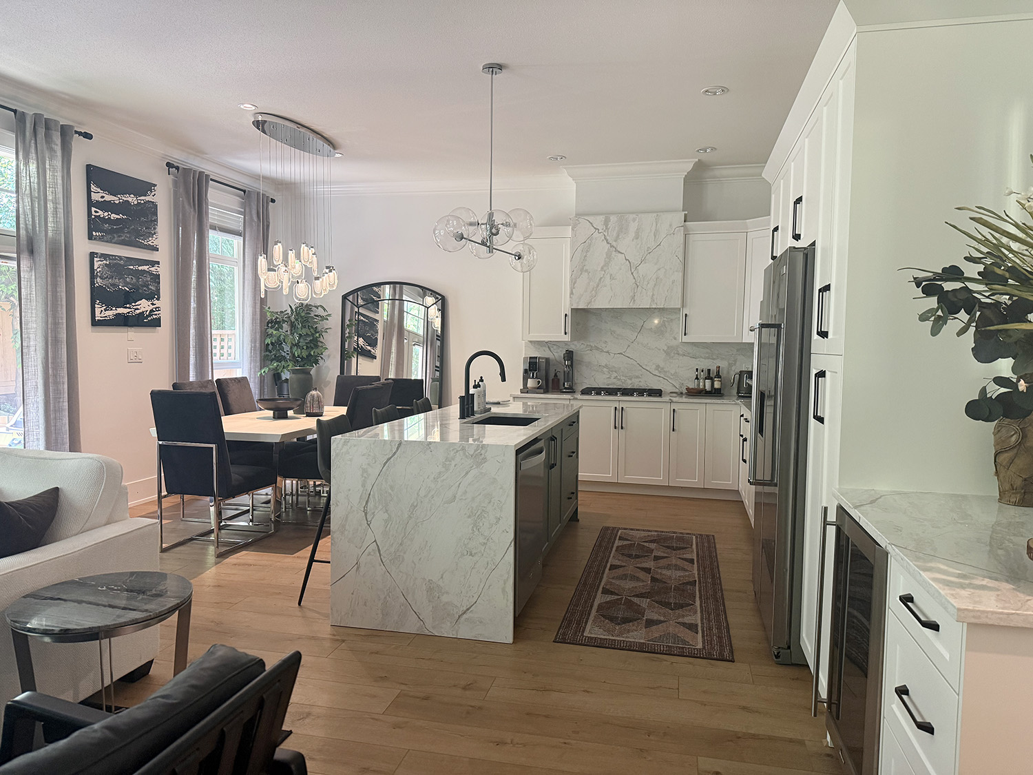 White kitchen cabinet renovation with olive green island, quartz countertop backsplash and light wood flooring