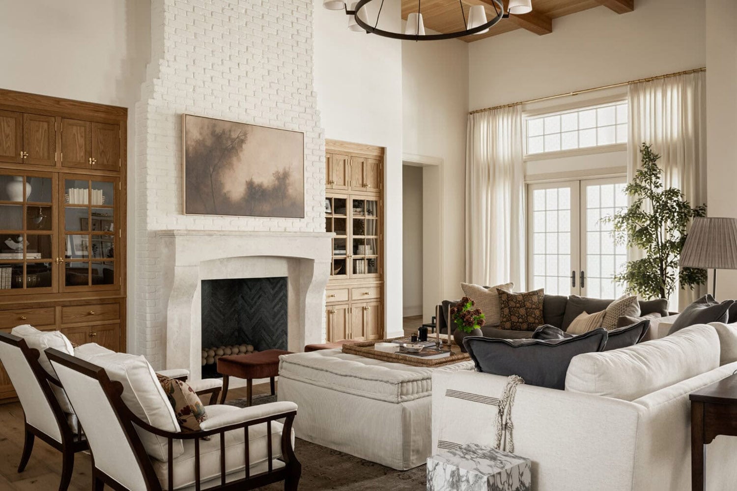 Modern farmhouse living room with a white brick fireplace and a vaulted wood-paneled ceiling with beams.