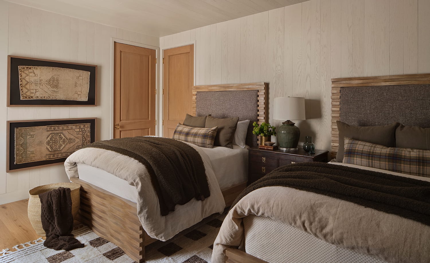 Guest bedroom with light oak wood flooring, and bedding in shades of brown