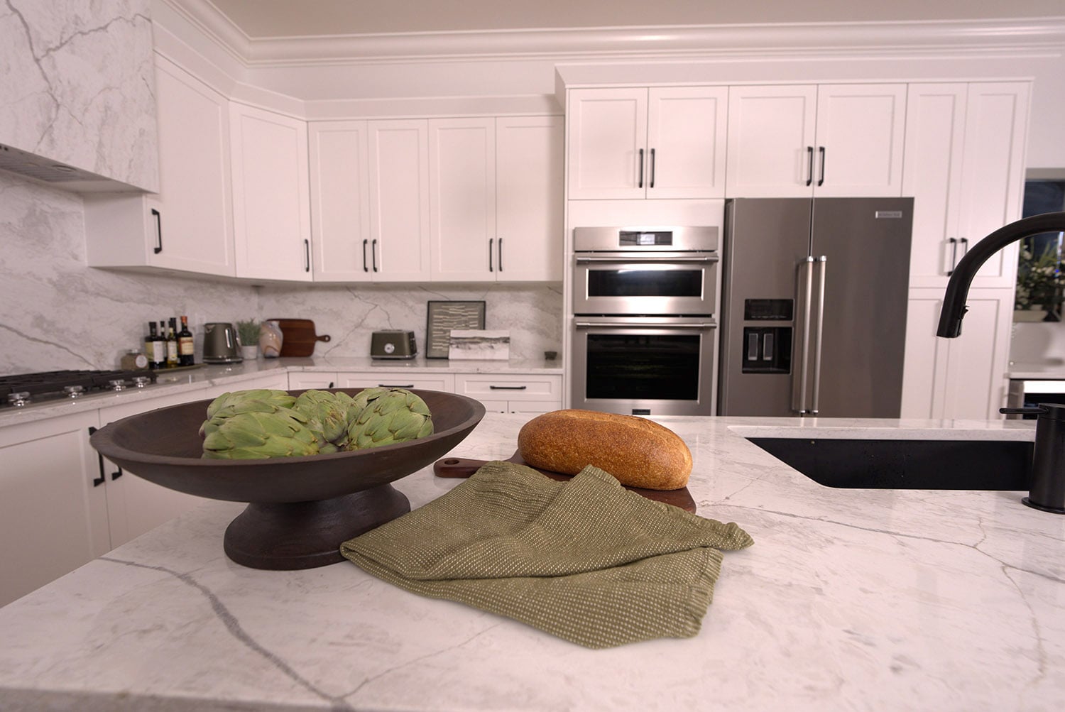 Kitchen designed by Tracy Svendsen with white cabinets and seamless quartz backsplash and countertops.