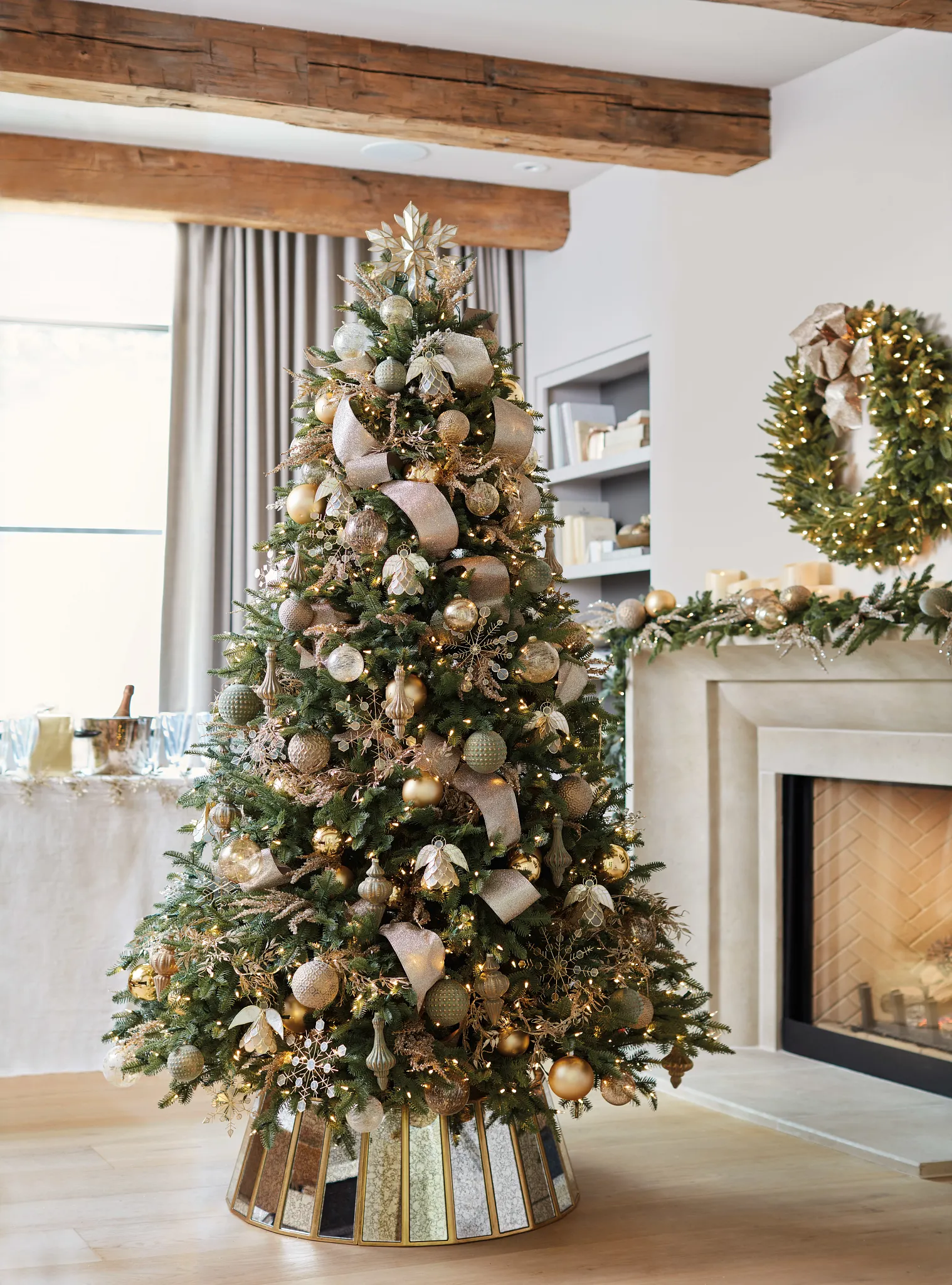 Modern Christmas tree with rose gold ribbon warm amber ornaments olive green and gold with crystal snowflakes and metallic angels