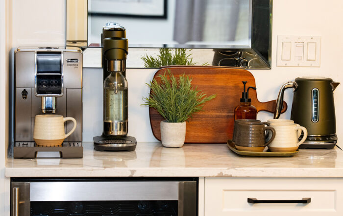 Home coffee bar ideas featuring an espresso machine and ceramic mugs styled on a kitchen counter
