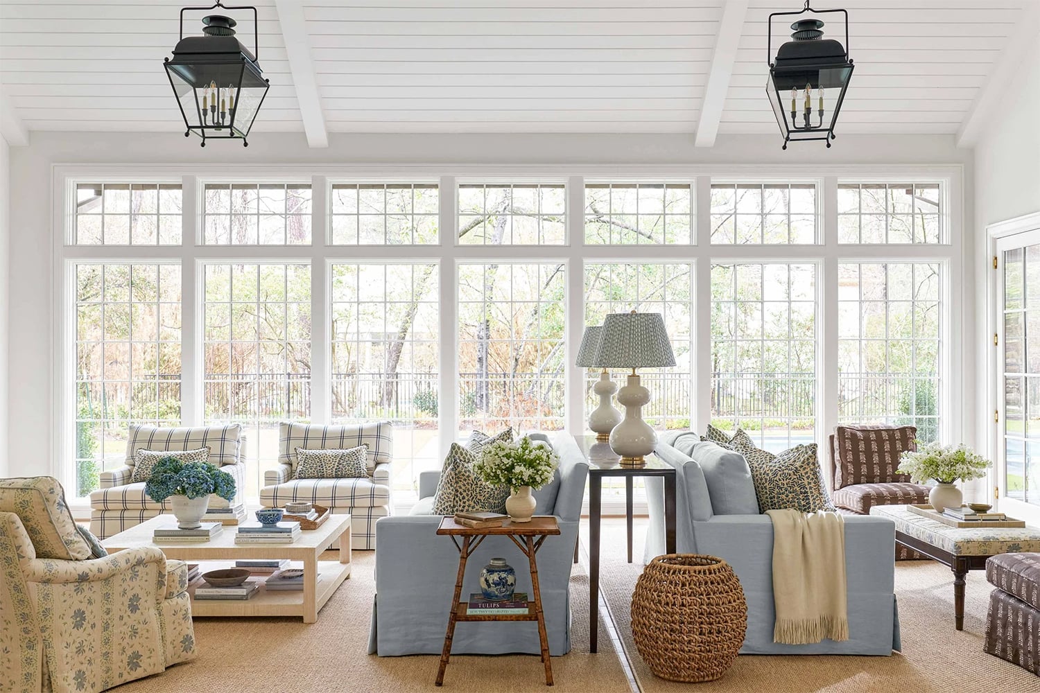 Large coastal living room with natural light, two seating areas, and a mix of playful prints.
