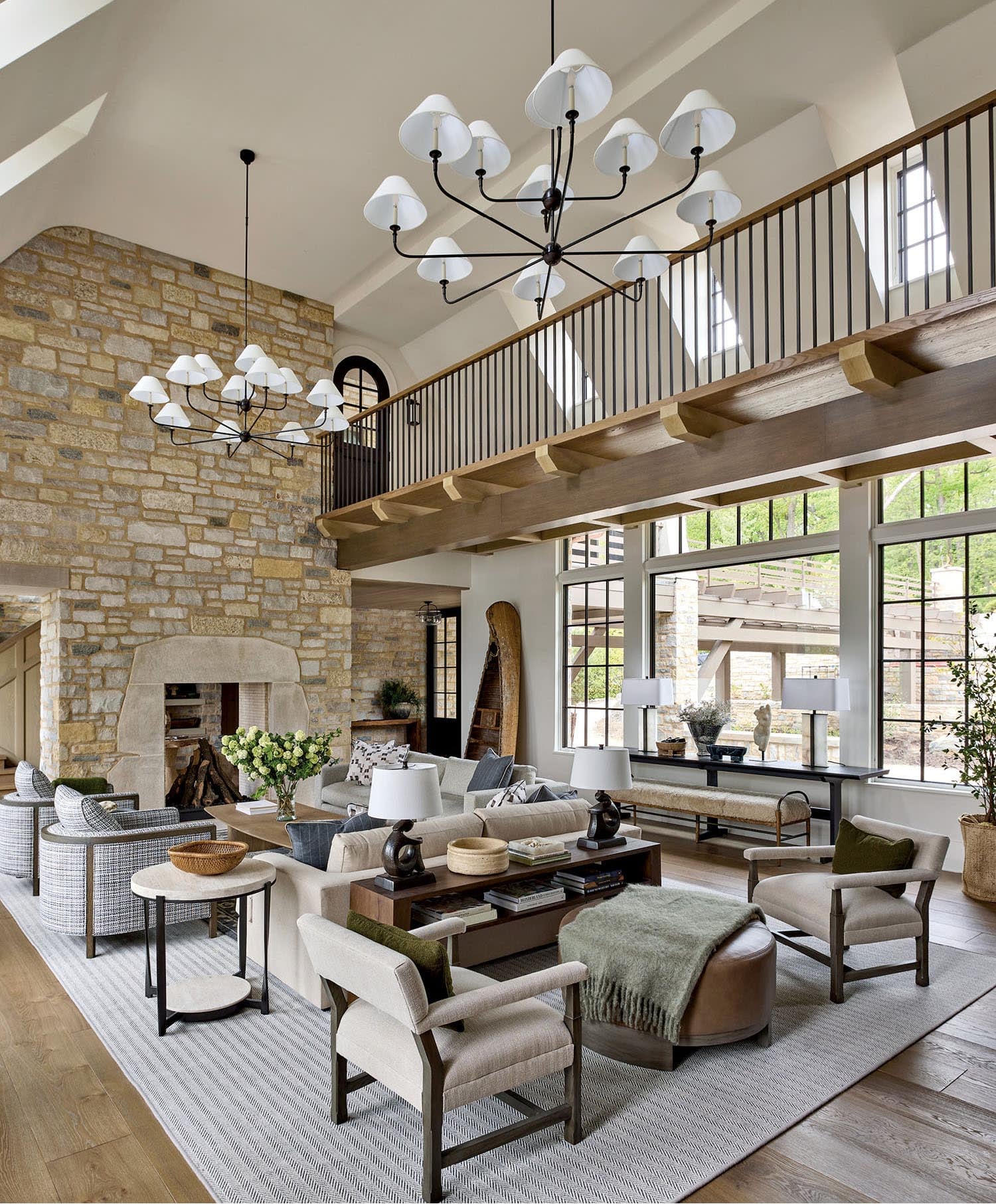 Coastal living room with light oak flooring, stone fireplace and high ceilings.