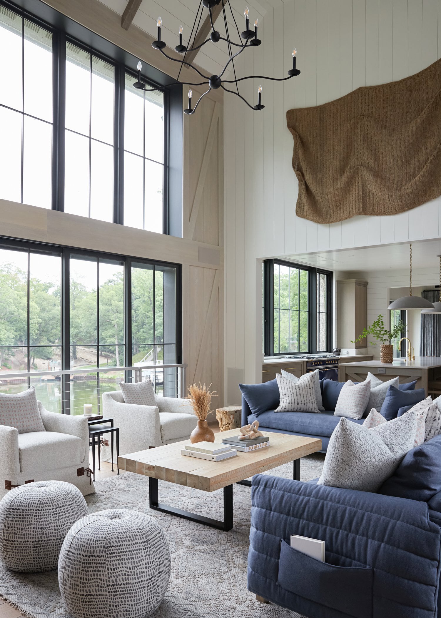 Modern coastal living room with shiplap walls, light oak flooring and navy blue sofa.