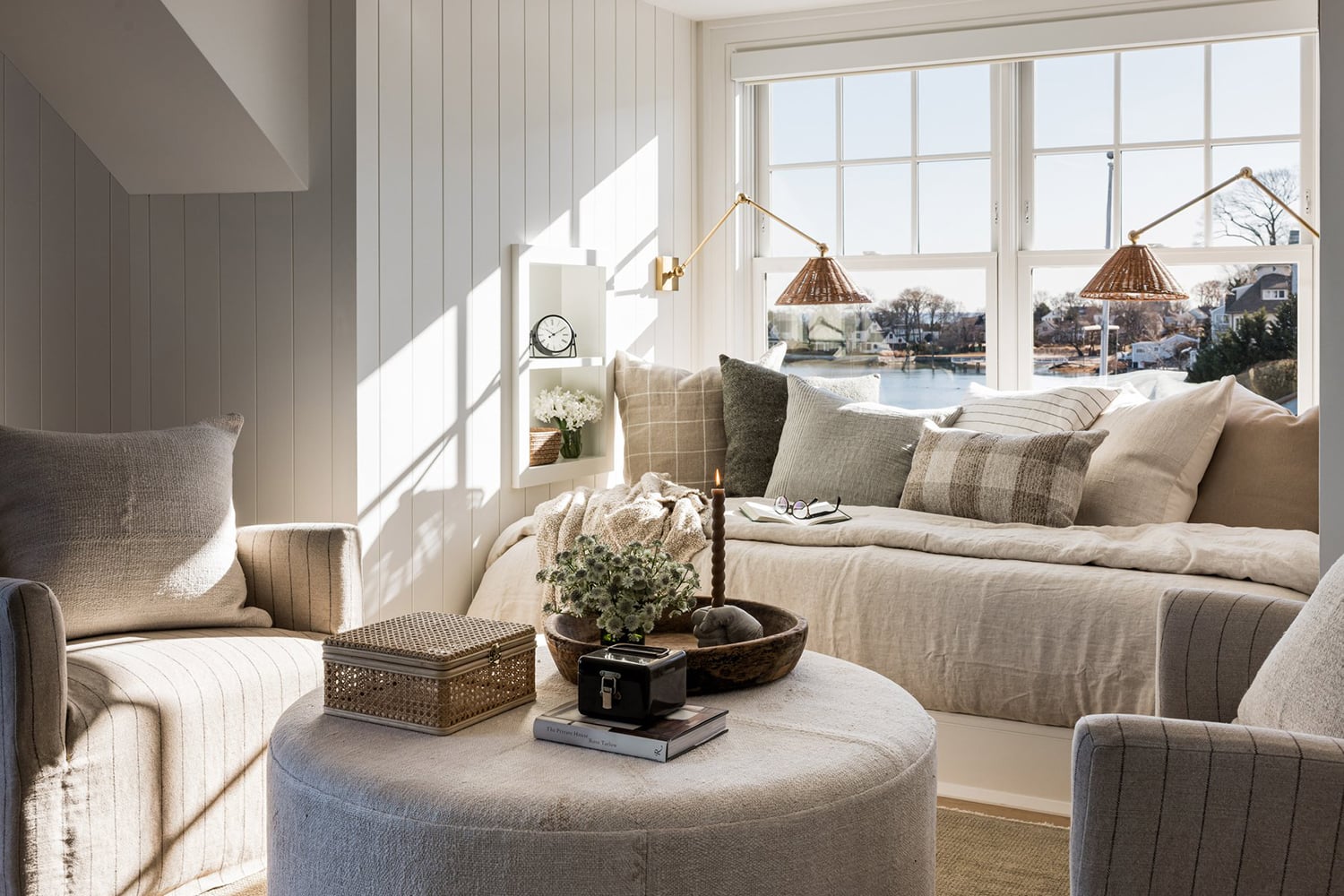 Modern coastal living room with a neutral palette, layered textures and shiplap walls.