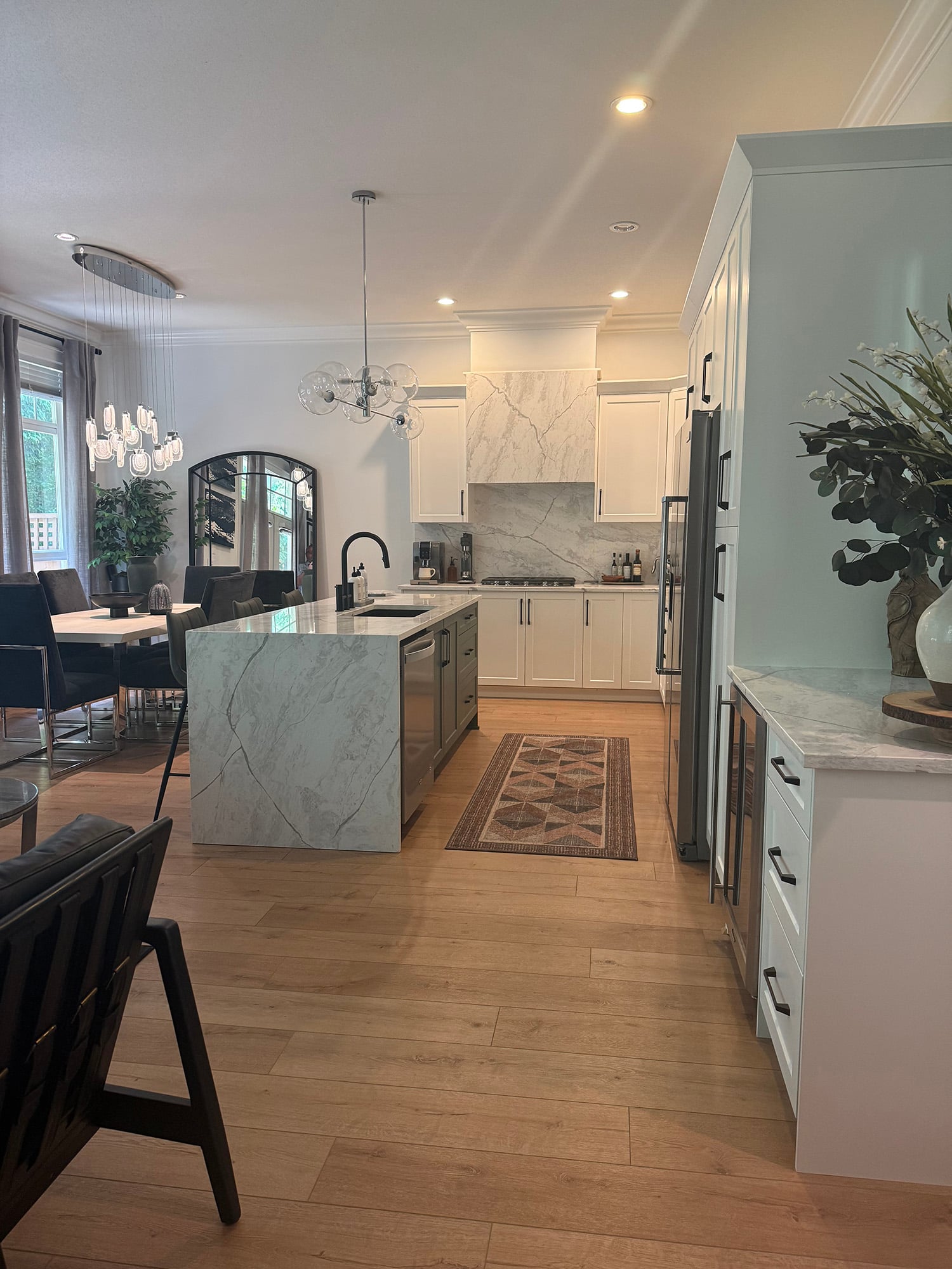 White quartz range hood matching countertops and backsplash in Tracy Svendsen kitchen with white cabinets and olive green island