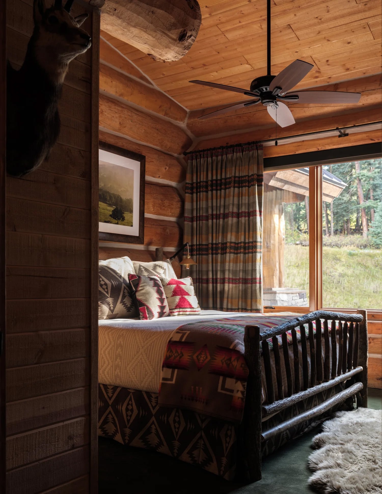 Rustic log cabin bedroom with a log bed and southwestern textiles. 