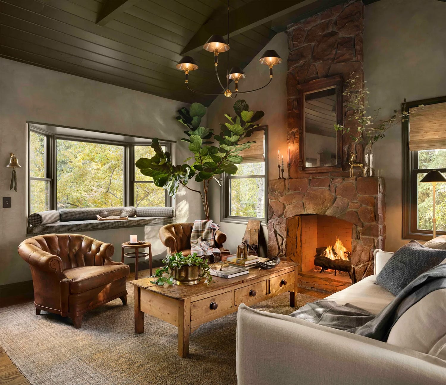 Gaine's Colorado guest cottage with stone fireplace, vaulted wood ceiling and leather chairs.