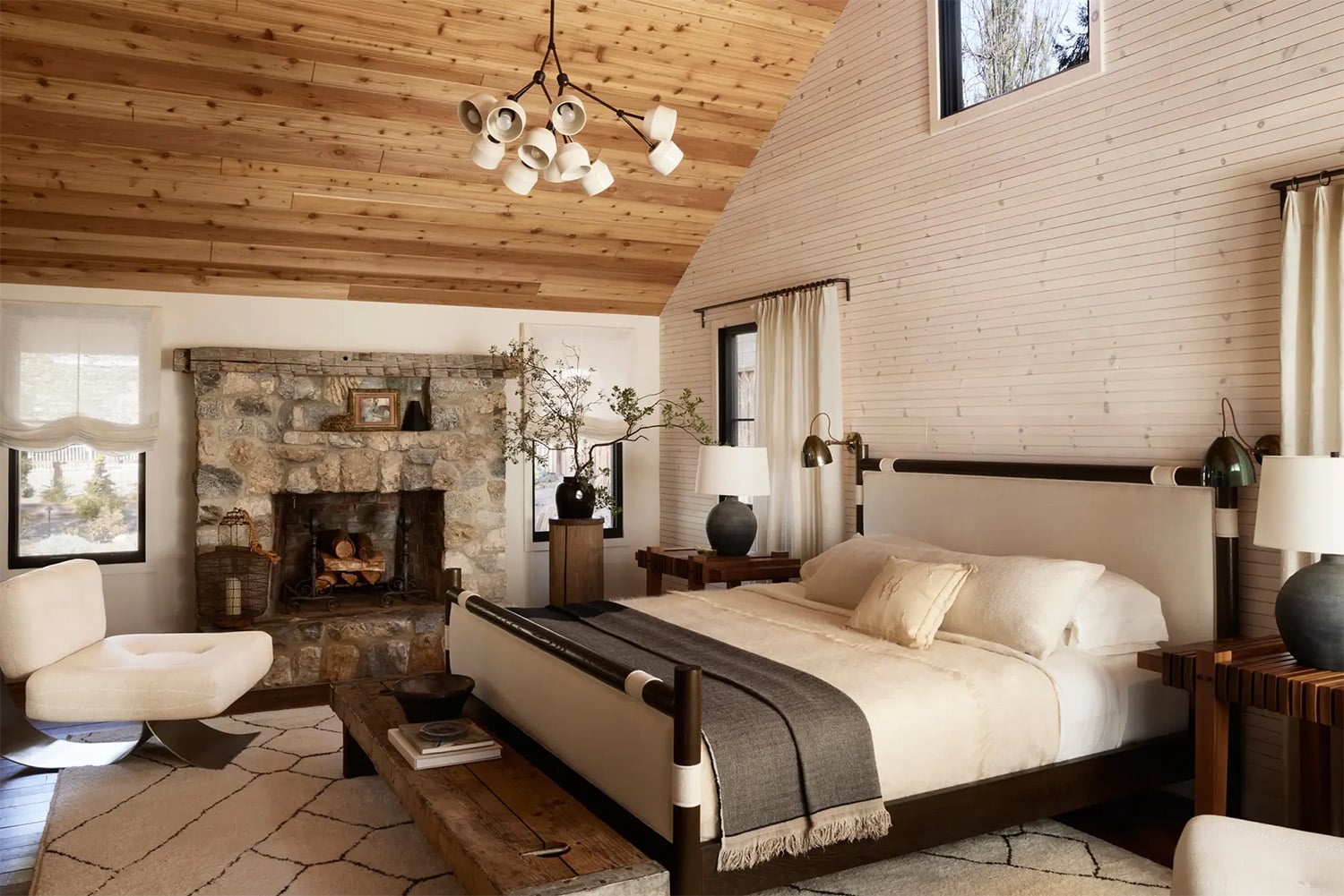 Rustic bedroom with vaulted wood ceiling and stone fireplace