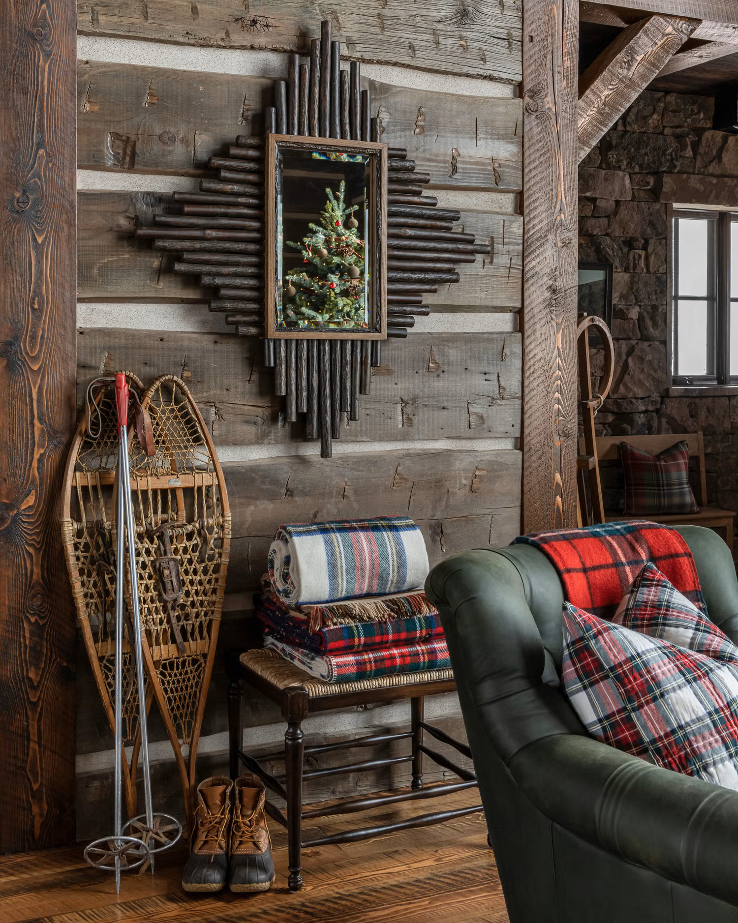 Log cabin decorated for Christmas with plaid blankets and pillows